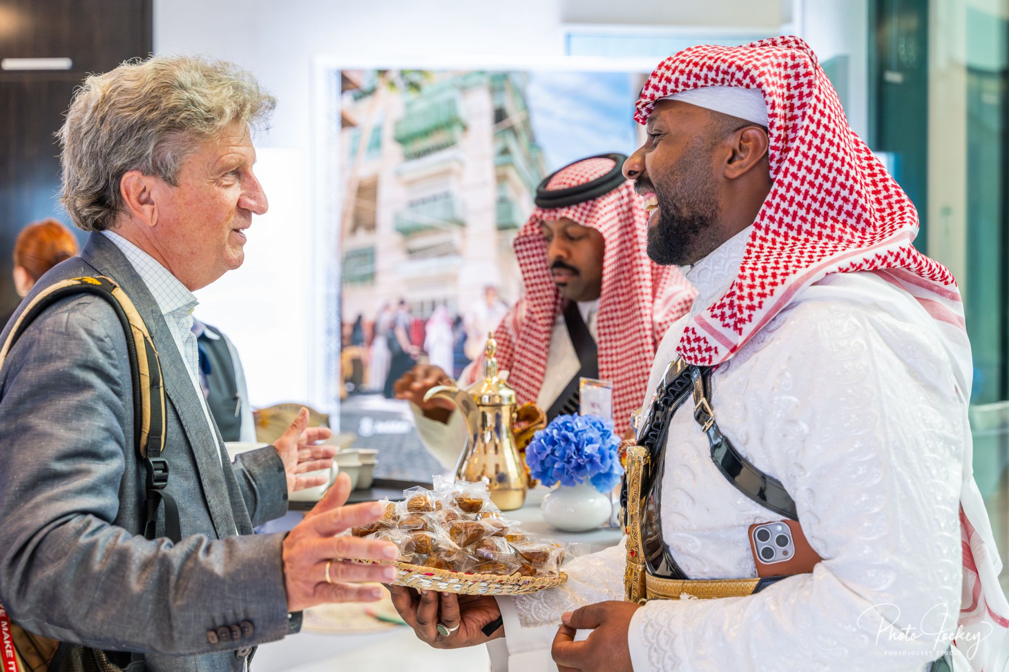 two men chatting around tradional food from saudi arabia