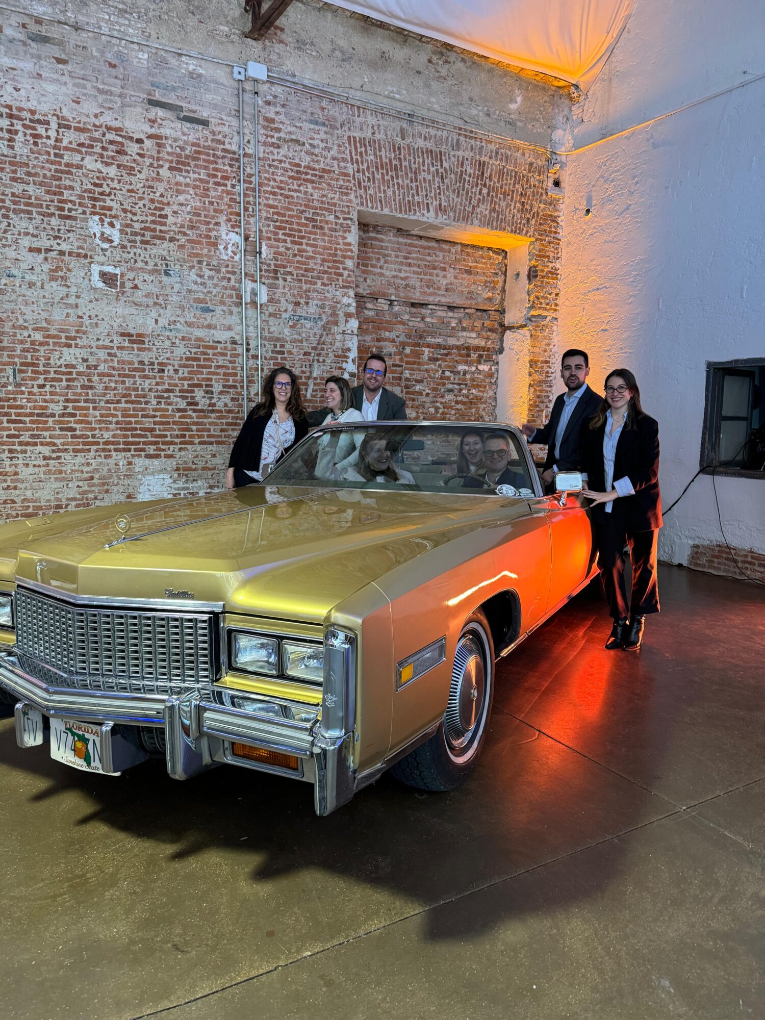 people standing around classic american gold car