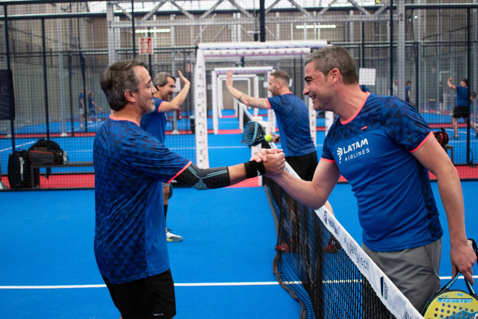 people on padel court high fiving