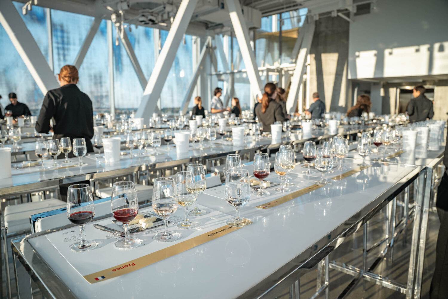 Tables full of empty wine glasses in a modern conference room