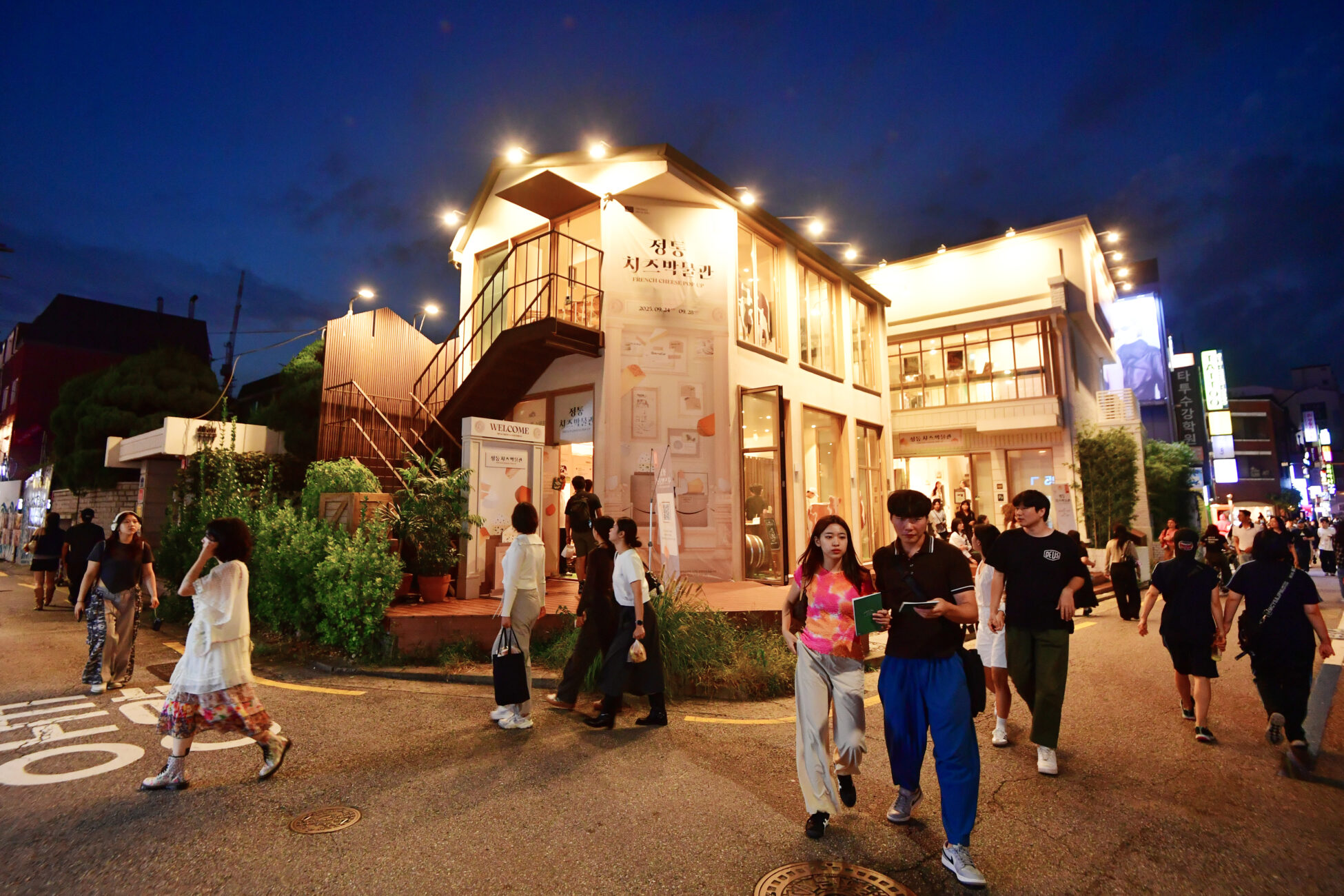 Cosy building at night with people surrounding it