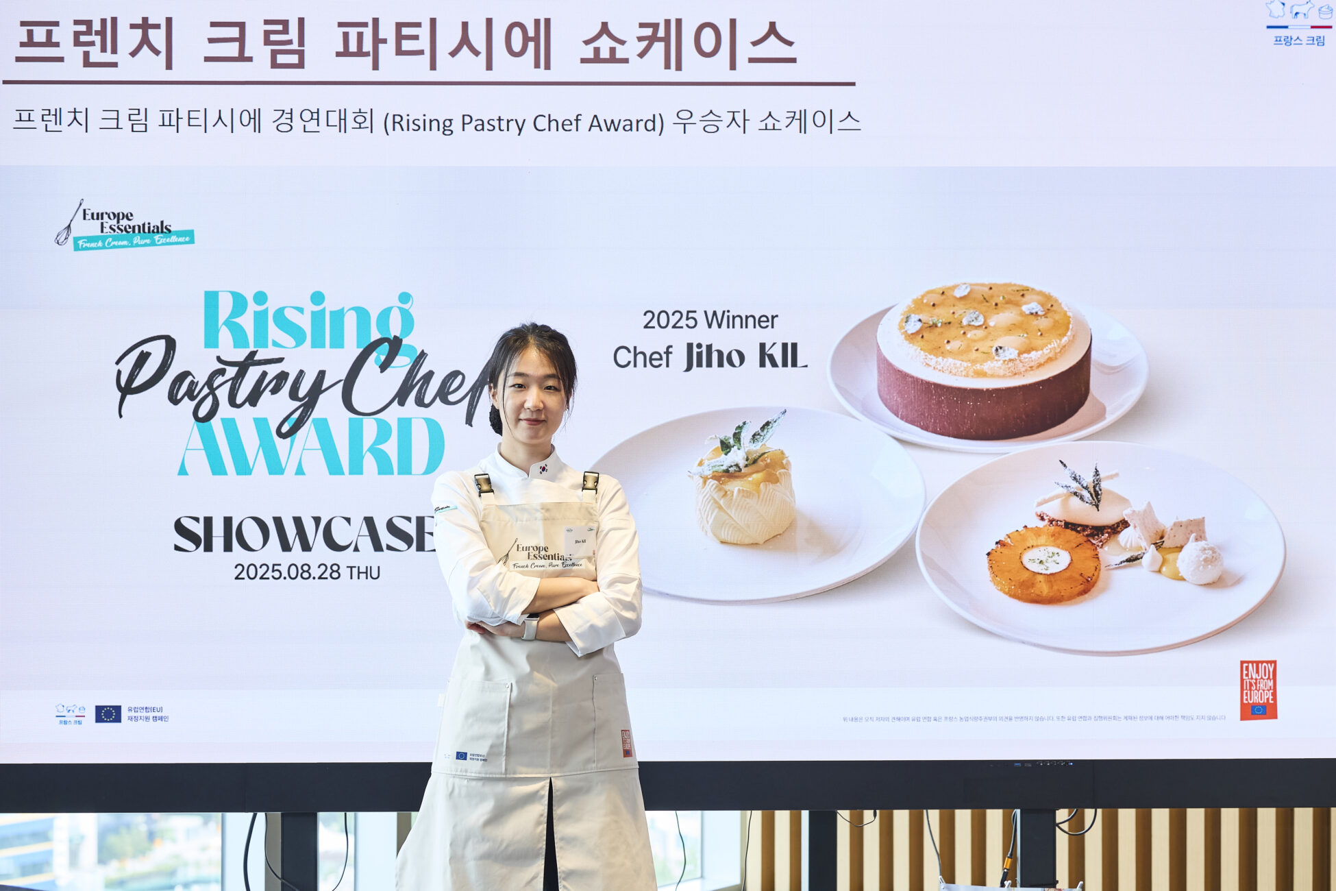 pastry chef posing in front of poster of deserts