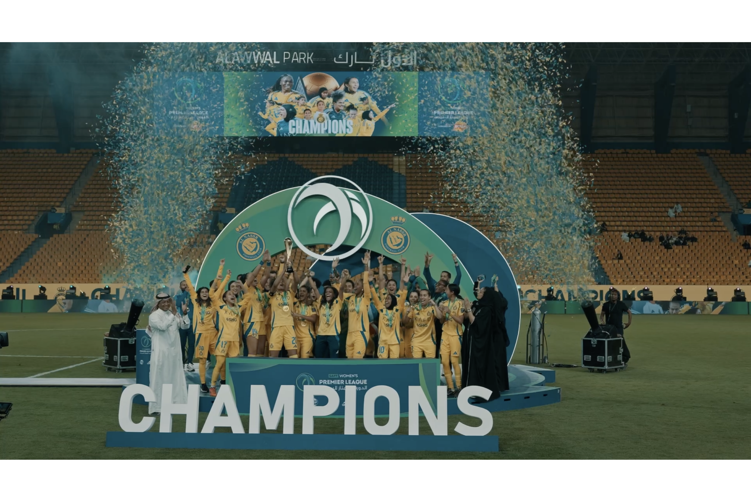 Women football team celebrating by the podium with confetti