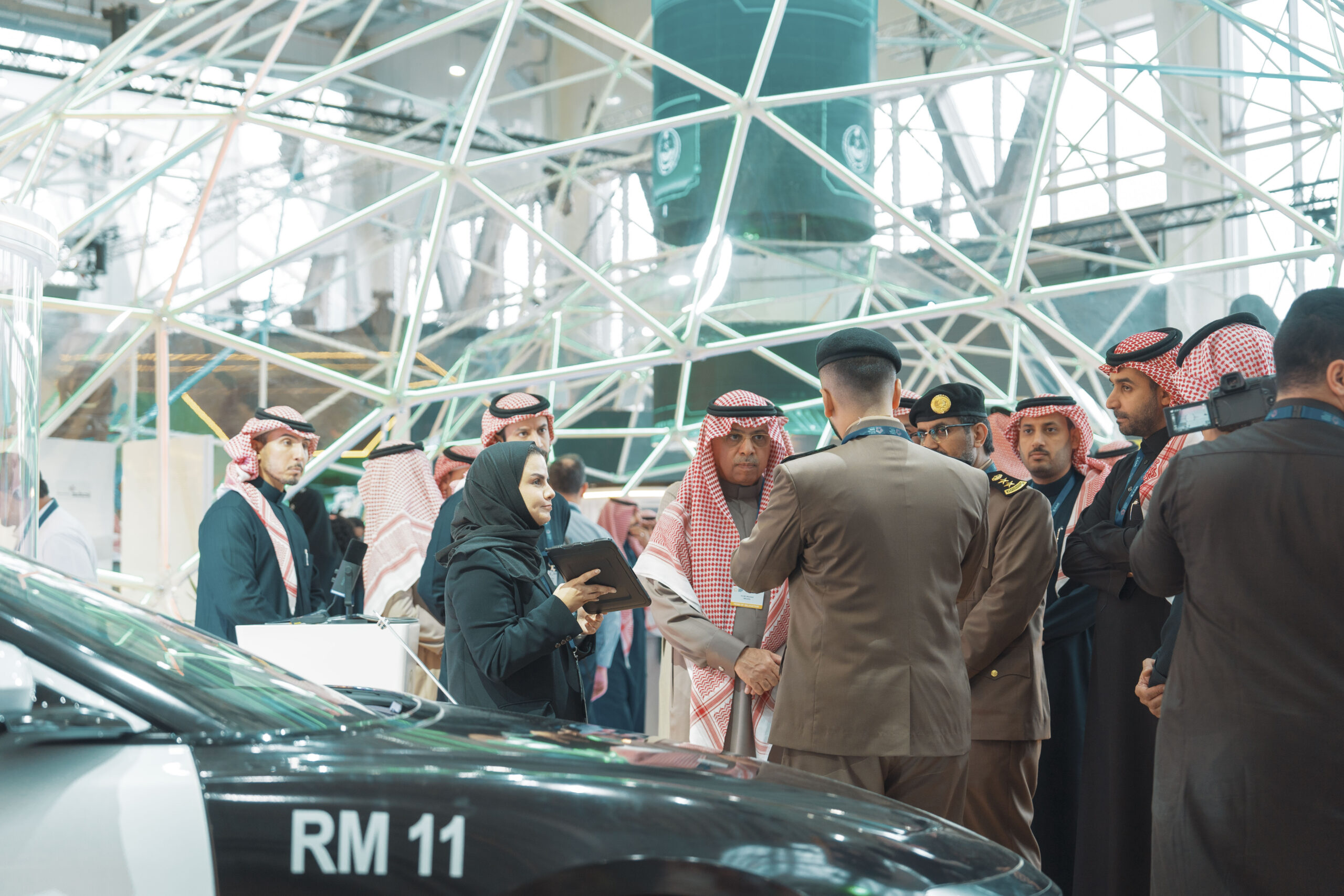 people talking next to police car at world defense show