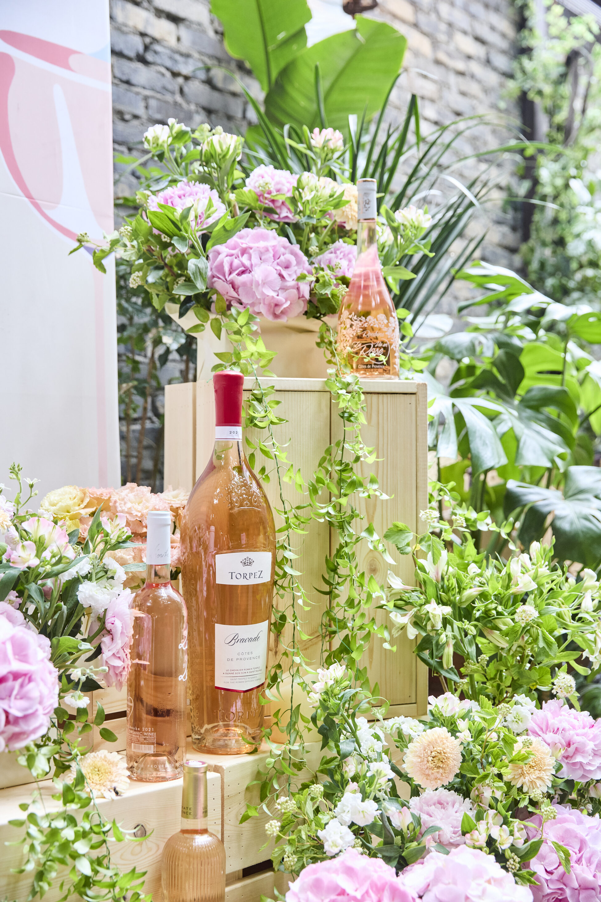 A beautiful flowers set up with a rosé bottle